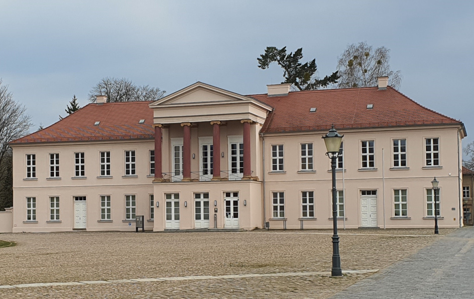 Frontansicht des Dienstgebäudes des Straßennauamtes Neustrelitz. Davor befindet sich ein großer Platz, der gepflastert ist.. © strassen-mv.de Frontansicht des Dienstgebäudes des Straßennauamtes Neustrelitz. Davor befindet sich ein großer Platz, der gepflastert ist..