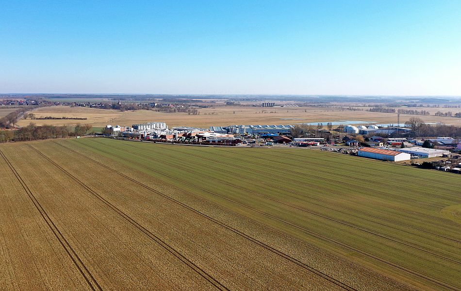 Luftbild der Landschaft am Rand von Dargun mit landwirtschaftlichen Flächen und einem Gewerbegebiet vor Beginn der Bauarbeiten.