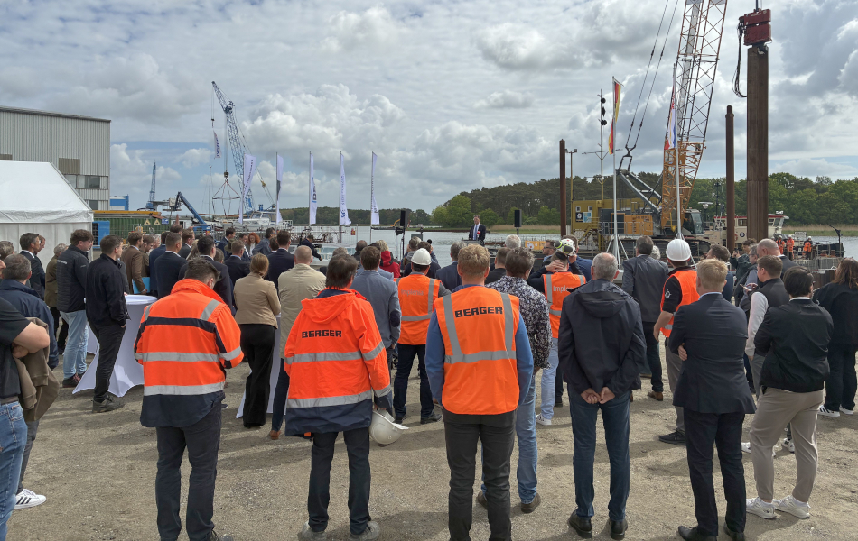 Publikum beim Baustart der Peenestrombrücke mit Gästen, Baukränen und Baustellenbereich am Wasser. © strassen-mv.de Publikum beim Baustart der Peenestrombrücke mit Gästen, Baukränen und Baustellenbereich am Wasser.