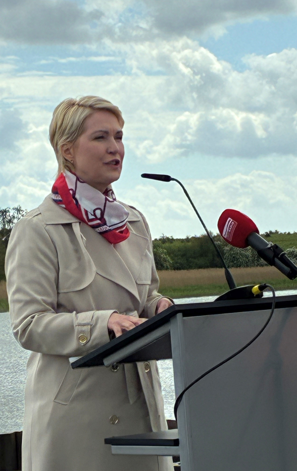 Ministerpräsidentin Manuela Schwesig am Redner-Pult beim Baustart der Peenestrombrücke mit Mikrofonen und Wasserfläche im Hintergrund. © strassen-mv.de Ministerpräsidentin Manuela Schwesig am Redner-Pult beim Baustart der Peenestrombrücke mit Mikrofonen und Wasserfläche im Hintergrund.