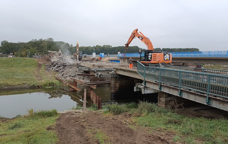 Eine alte Brücke führt über einen Fluss. Auf der Brücke stehen zwei Bagger und tragen das Bauwerk ab. © strassen-mv.de Eine alte Brücke führt über einen Fluss. Auf der Brücke stehen zwei Bagger und tragen das Bauwerk ab.