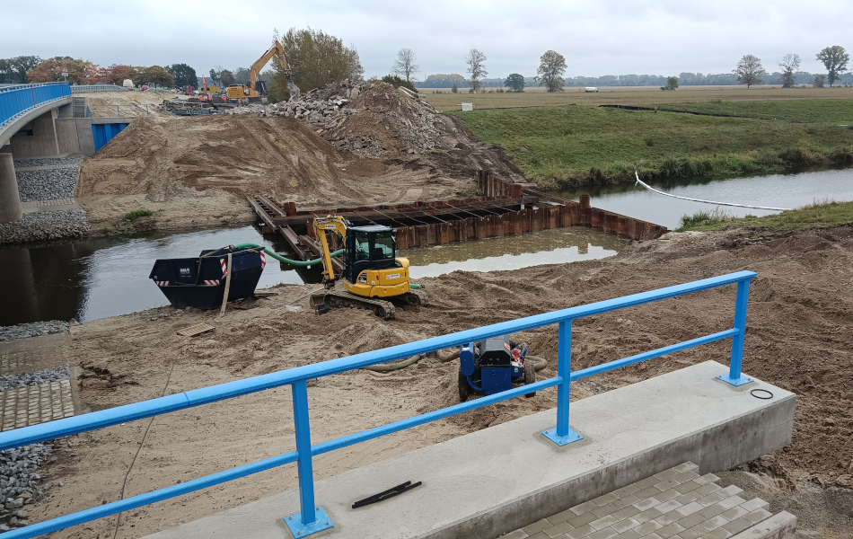 Restfundamente einer alten Brücke sind in einem Fluss zu sehen. An den Ufern stehen Bagger zum weiteren Abbruch des Bauwerks bereit. © strassen-mv.de Restfundamente einer alten Brücke sind in einem Fluss zu sehen. An den Ufern stehen Bagger zum weiteren Abbruch des Bauwerks bereit.