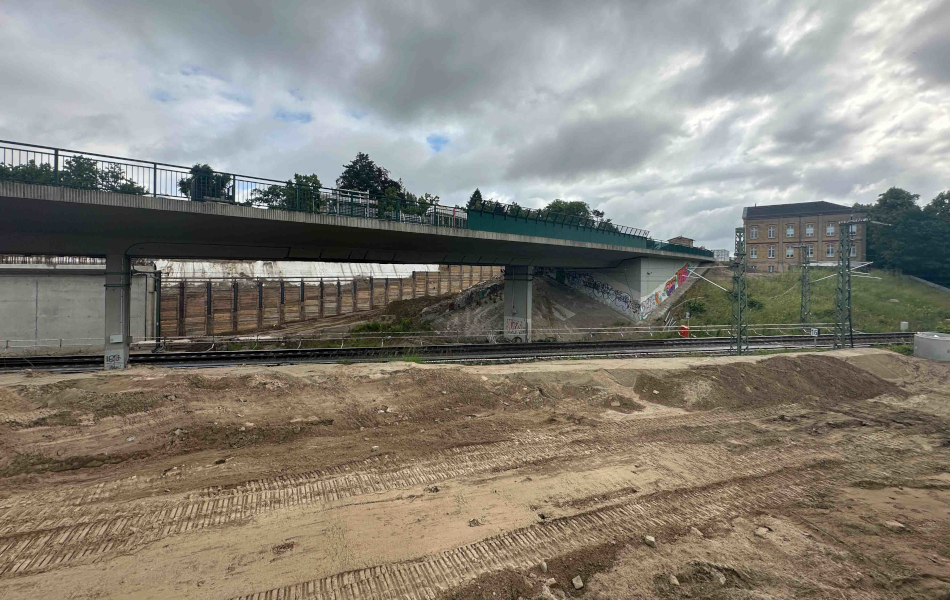 Brückenbauwerk in Waren über einer Bahnstrecke mit Baustellenfläche, Böschung und angrenzender Bebauung. © Foto Uwe Brückenbauwerk in Waren über einer Bahnstrecke mit Baustellenfläche, Böschung und angrenzender Bebauung.