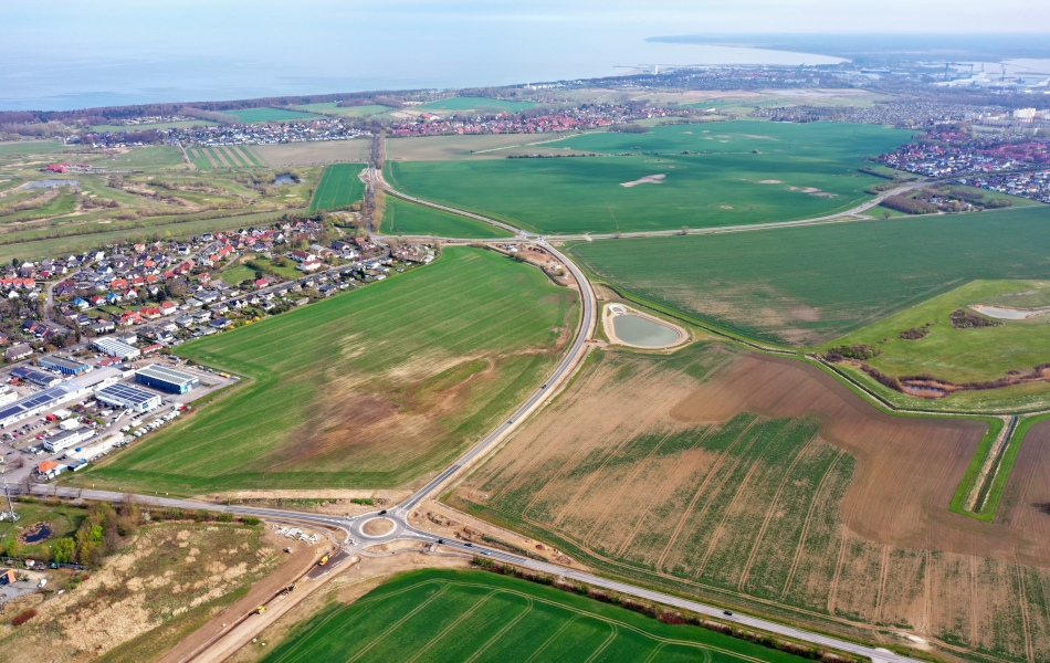 Blick von oben: Eine neugebaute Straße führt über Felder am Ort Elmenhorst vorbei. Im Hintergrund sind weitere Orte und die Ostsee. © strassen-mv.de Blick von oben: Eine neugebaute Straße führt über Felder am Ort Elmenhorst vorbei. Im Hintergrund sind weitere Orte und die Ostsee.