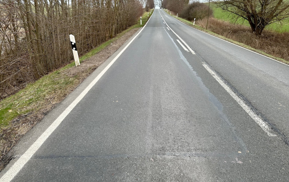 Ein großes Teilstück einer Straße besteht aus andersfarbigen Asphalt. Um den Bereich herum führt ein schmaler, gummiartiger Streifen.
